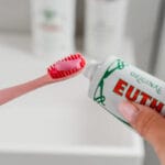 Dentifrice Euthymol Original - Soin buccal sans fluor avec un goût unique et une couleur rose. Produit Image dentifrice rose sur brosse à dents 