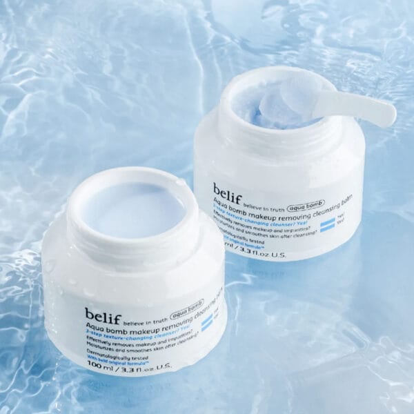 belif Cleansing Balm 100ml – Feuchtigkeitsspendender Abschminkbalsam mit Lotusblume & Vitamin E. Imagebild mit Applikator, ohne Deckel auf blauem Hintergrund.