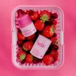 belif Multi Vitamin Pink Lipcerin 15ml - Nourishing lip balm & mask with pink color, cranberry-strawberry aroma and multi-vitamin complex. Picture lip balm in shopping basket with berries. 