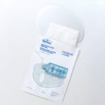 Dr. Belmeur Spot Care Intense Face Mask 30ml – beruhigende Tuchmaske mit Teebaumöl, Salicylsäure und Panthenol für unreine Haut. Abbildung Produkt, Verpackung offen und Flüssigkeit tritt aus.
